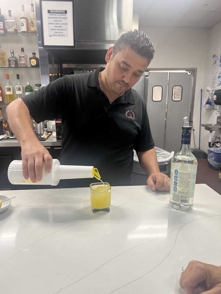An NYBB bartender pouring a cocktail at the bar