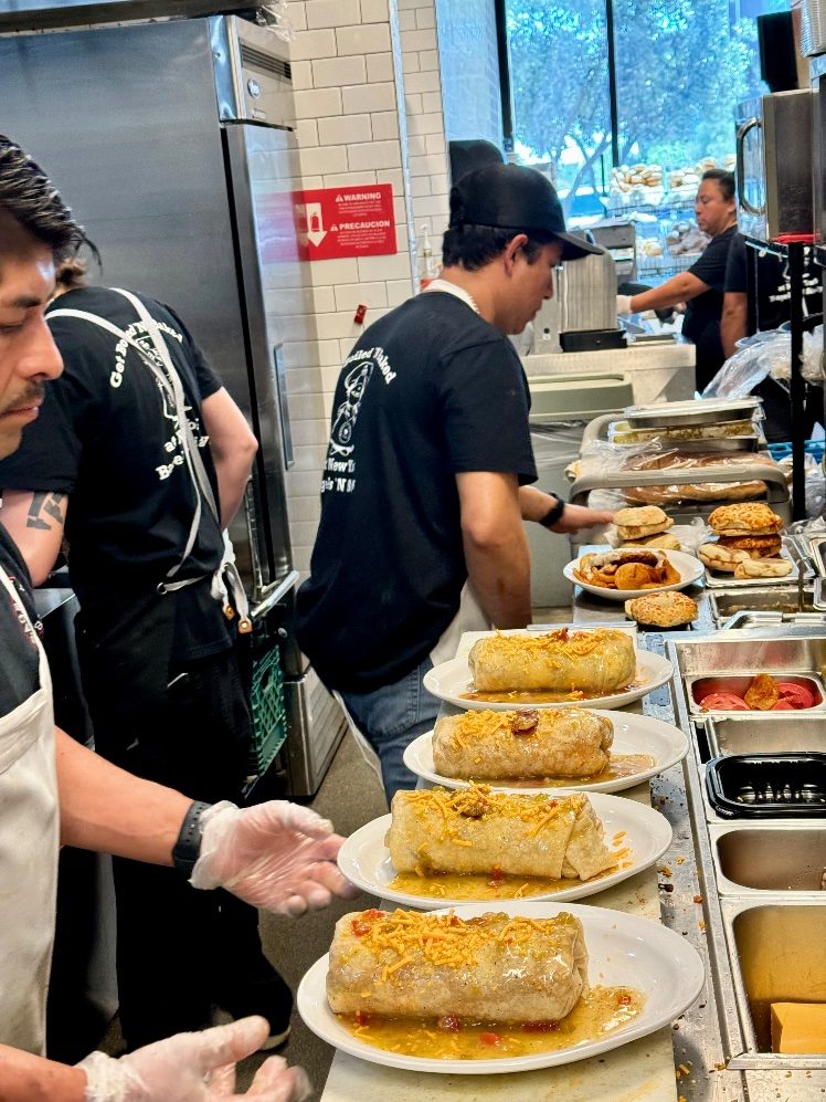 The kitchen team plating breakfast burritos