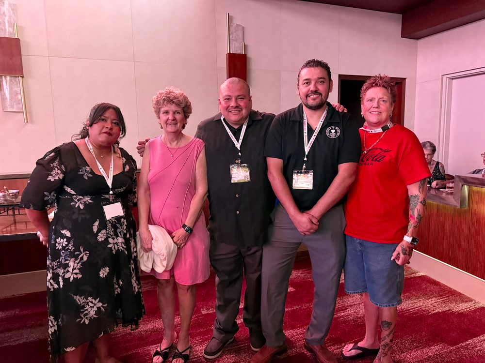 Five NYBB team members posing together at an event