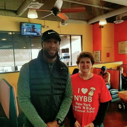 Larry Fitzgerald posing with a team member in a red NYBB shirt