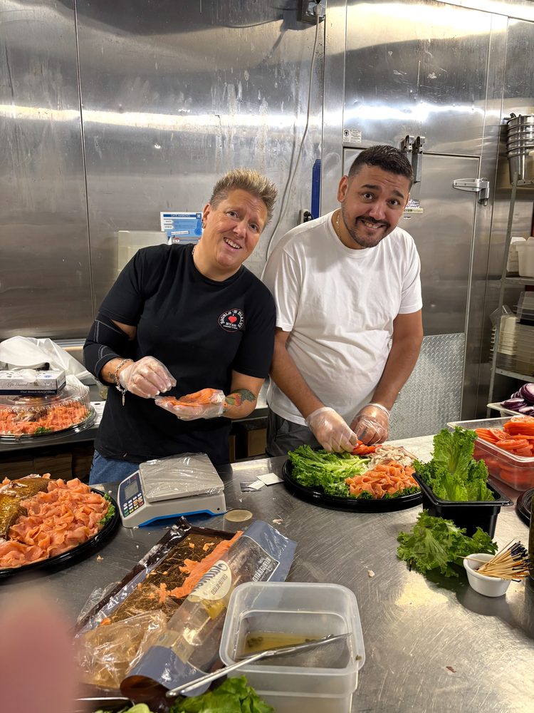 Shelley and a team member building lox platters in the kitchen