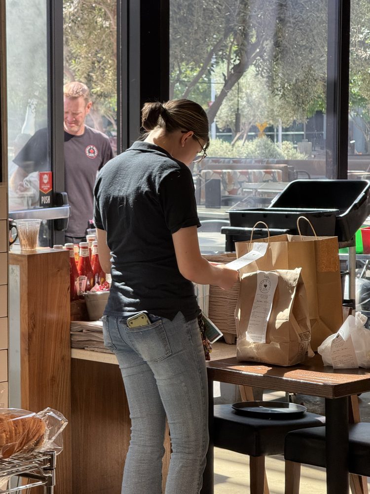 A team member packing to-go bags at the counter