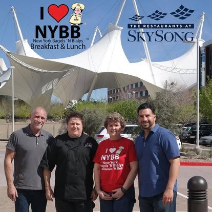 Four NYBB team members posing outside the SkySong location