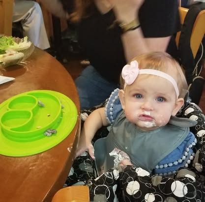 A baby enjoying her first bites at NYBB
