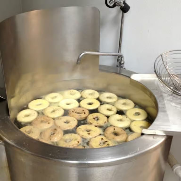 Bagels boiling in the kettle before baking
